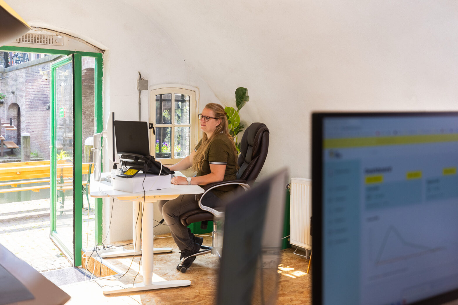 Een vrouw zit achter haar computer in een kantoor aan de Utrechtse gracht
